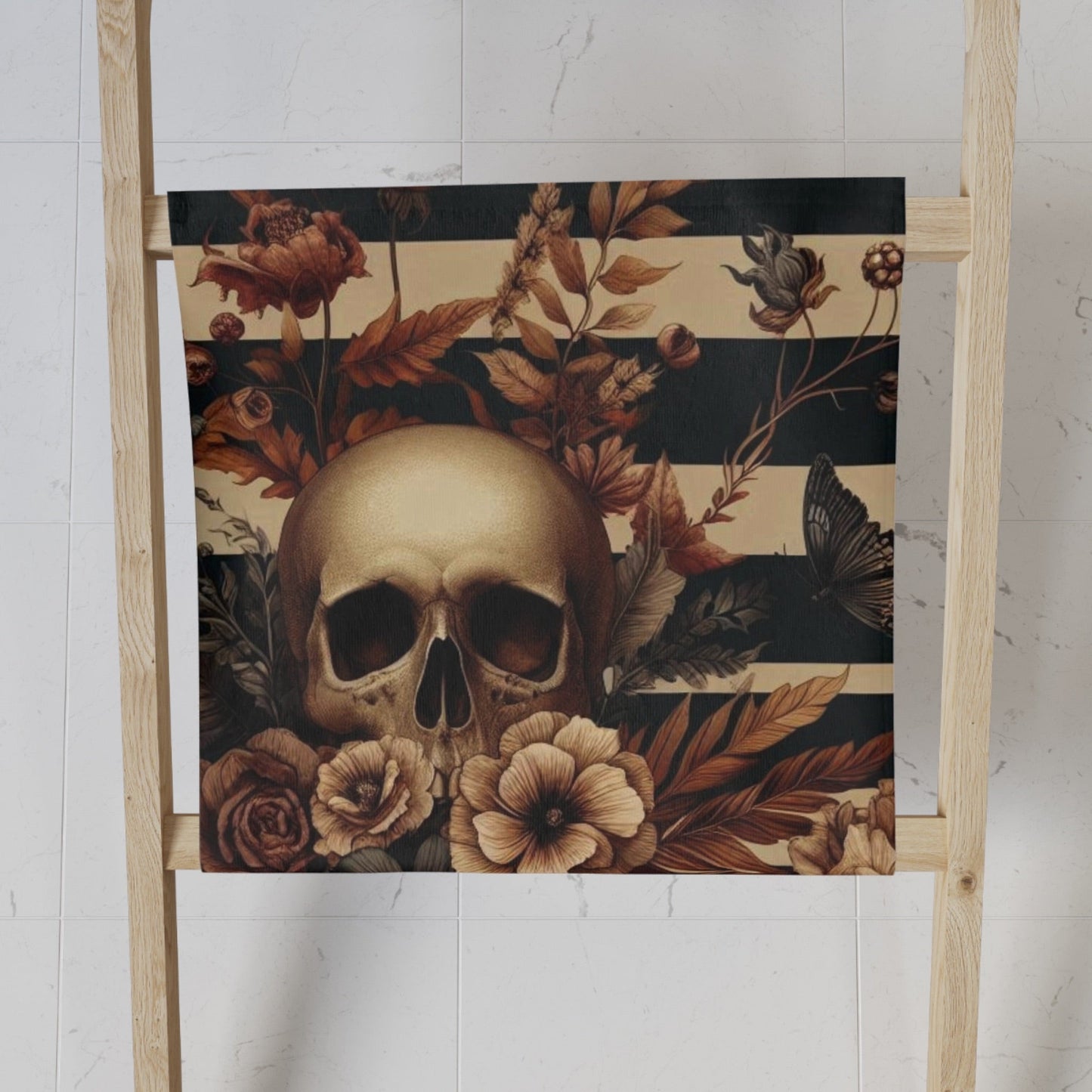 Skull and floral designed towel on a ladder against a white wall