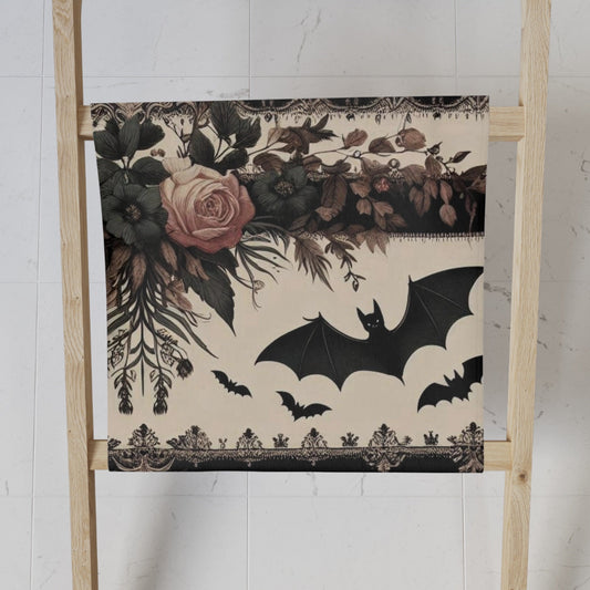 Decorative towel with bats and flowers on a wooden ladder against a white wall.
