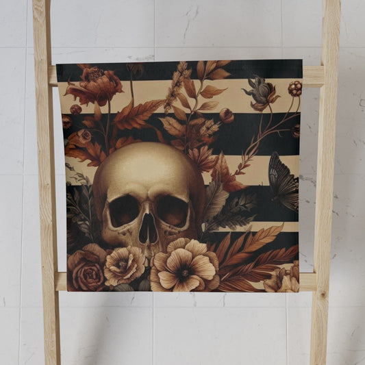 Skull and floral designed towel on a ladder against a white wall
